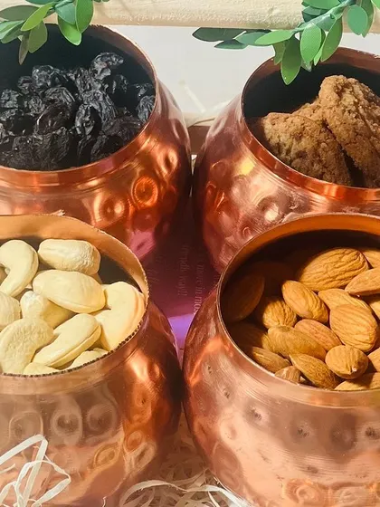 A close-up of the contents of the copper jars: raisins, cookies, cashews, and almonds. I use high-quality fillings for all my corporate hampers.