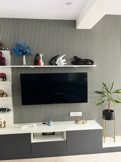 This TV unit features a modern design with a mix of closed cabinets and open shelving for decor. The vertically grooved back panel adds texture and visual interest, creating a stylish focal point for the living room.