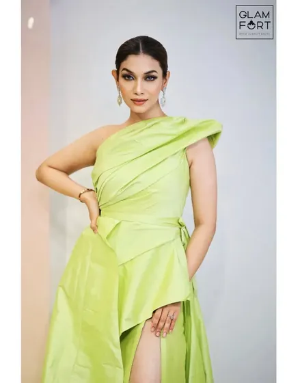 A full-length view of this elegant green gown. The makeup is kept soft and glowing to complement the dress, with a classic winged liner and a peachy-nude lip.