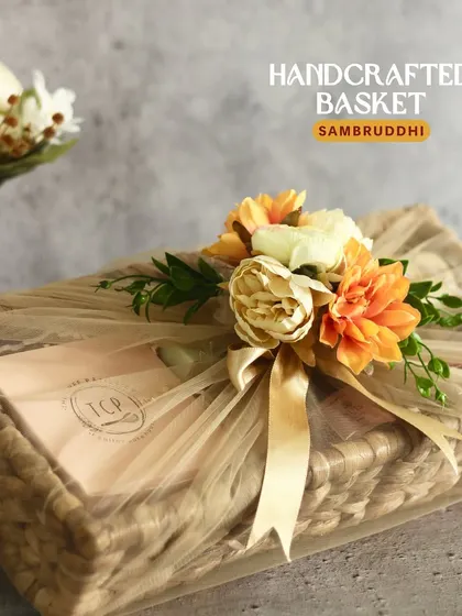 The Samruddhi basket hamper is designed for elegant festive gifting. This handcrafted, reusable basket is filled with a tea cake, granola, cookies, mukhwas, nuts, and a diya for a complete Diwali celebration.