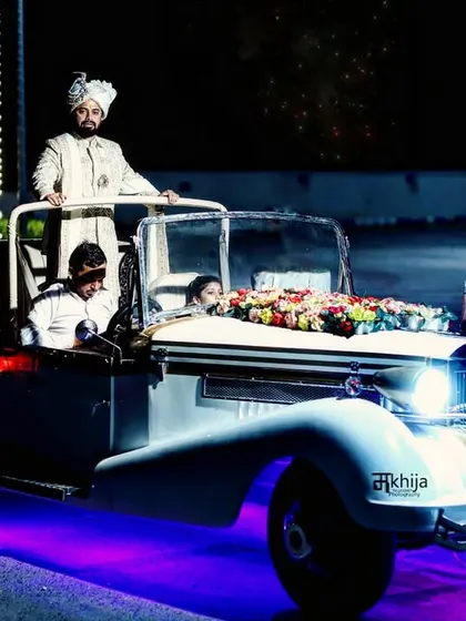 The groom's entry is a highlight of any Indian wedding, and I make sure to capture it with all its grandeur. This shot of the groom arriving in a vintage car, complete with dramatic lighting, shows my cinematic approach to documenting the baraat.