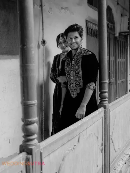 A classic black and white portrait of the couple on a balcony. This timeless shot captures their connection with a sense of old-world charm.
