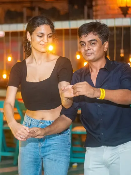 A focused pair practicing their moves. Our social is a great place to improve your dancing in a real-world setting.