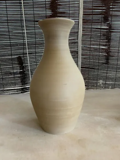 A collection of large, unglazed vases in various shapes and sizes. Each one is thrown on the wheel and showcases a different form, from classic curves to textured surfaces.