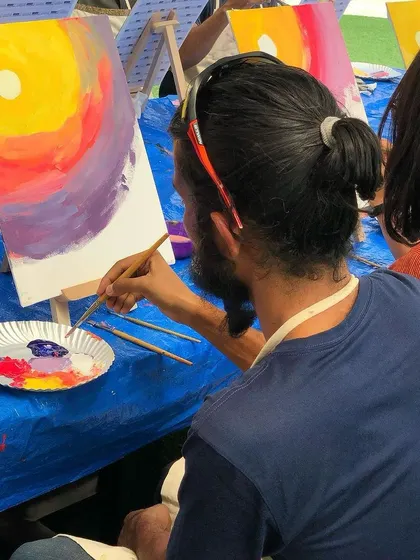 A guest painting a vibrant sunset at one of our workshops. The creative possibilities are endless.