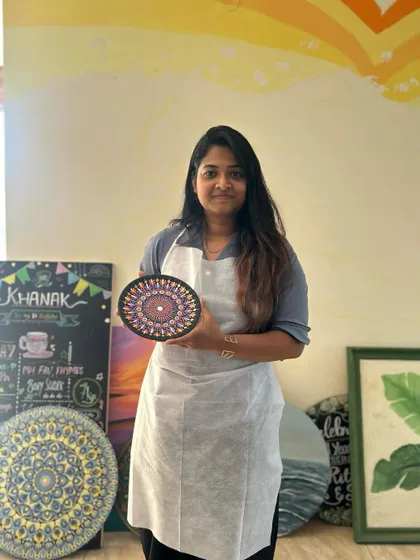 A participant with her finished dot mandala plate. The precision and color choices are fantastic.