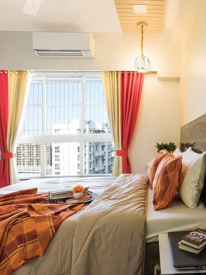 Another view of the bedroom, showcasing the large window that fills the room with natural light and offers a view of the city.