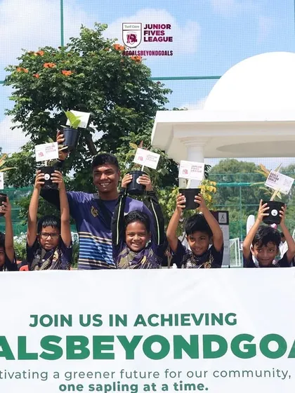 A youth team proudly holds up saplings as part of my #GoalsBeyondGoals initiative. I teach young athletes the importance of giving back to the community and the environment.