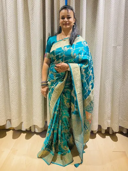 A self-makeover for an evening occasion, featuring a slightly more defined eye and a soft lip, paired with a gorgeous teal saree. This is a perfect example of an office-to-party transition.