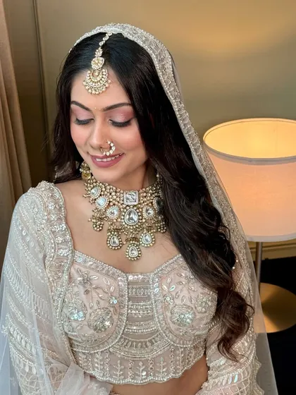 A happy, smiling portrait of the bride. The soft pink makeup enhances her joyful expression, creating a look that is both beautiful and full of life.