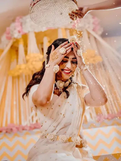 Capturing the pure joy of the Haldi ceremony. The bride is showered with flowers and turmeric, and my decor with its bright yellow drapes and floral accents creates a perfectly festive atmosphere.