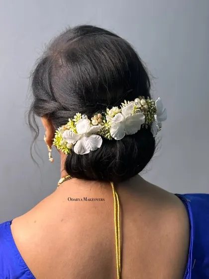 A classic low bun decorated with a beautiful floral hairpiece. This is a sophisticated hairstyle for mothers of the bride or groom.