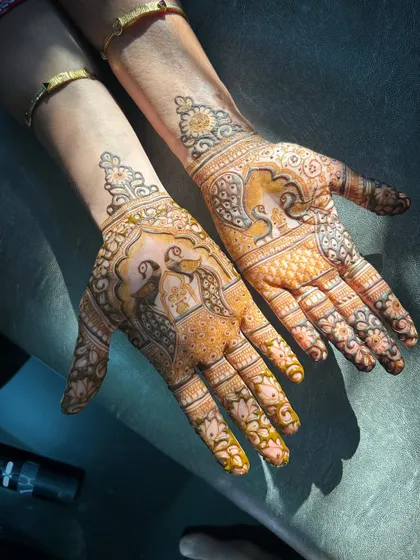 The golden hour glow on a fresh henna stain. This design features peacocks and elephants, and the sunlight really highlights the beautiful color.