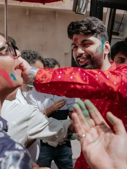 The groom joyfully participates in the Holi welcome, sharing a moment of fun with his guests. We believe in creating interactive experiences for everyone.