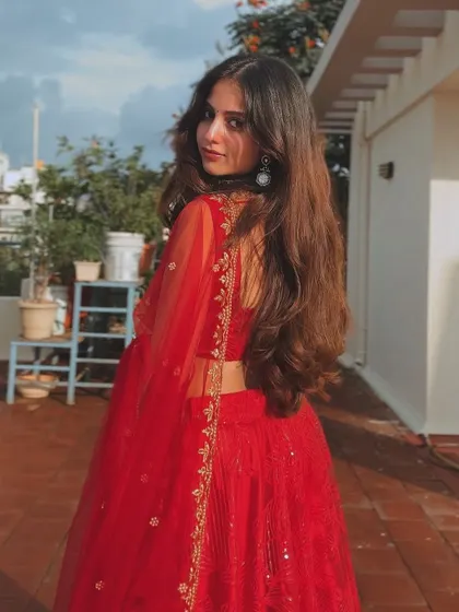 A back view of the red lehenga, showing the elegant drape of the dupatta.