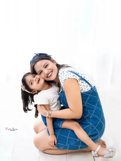 A warm and loving hug between a mother and her daughter. The simple, bright background keeps the focus on their beautiful connection.