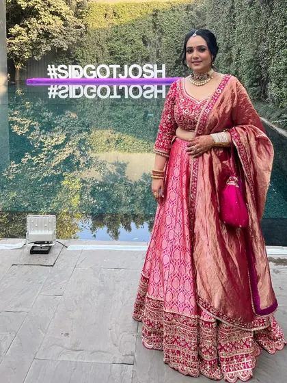 A full-length view of the custom pink Banarasi lehenga, showing how the rich fabric and intricate embroidery come together. This piece was designed for a wedding celebration.