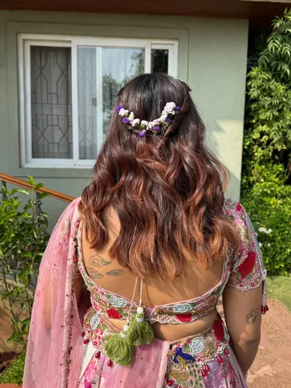 A close-up of the hairstyle, featuring a delicate floral accessory.