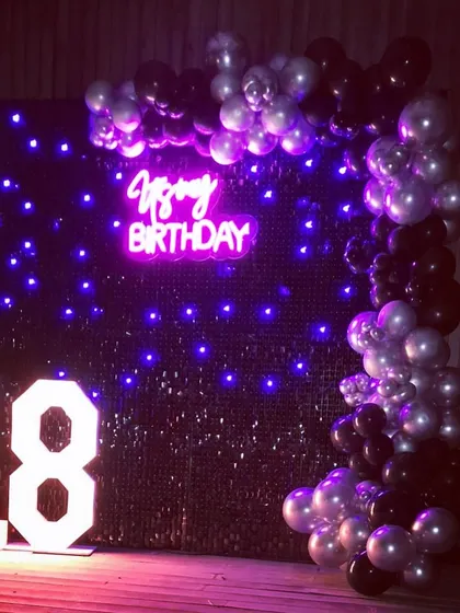 Turning 18 is a huge moment, and we marked the occasion with this chic setup. The black sequin wall with purple LED lights, a custom neon sign, and a black and silver balloon arch made for a stylish and modern party atmosphere.