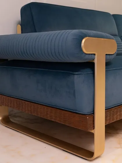 A close-up of a custom sofa, highlighting the elegant T-shaped brass handle and the rich, velvety texture of the blue upholstery. Every detail is considered to create a luxurious feel.