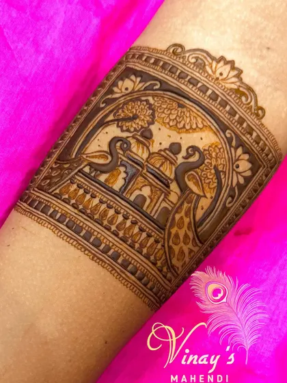 This arm band features two peacocks flanking a palace view, creating a symmetrical and regal design that is both beautiful and symbolic.
