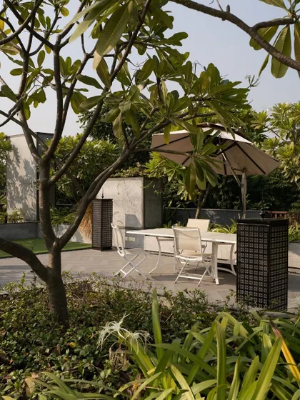 Strategic green spaces are key to our designs. This shaded outdoor area provides a cool, comfortable spot for relaxation, demonstrating how landscape integration can create more livable spaces.