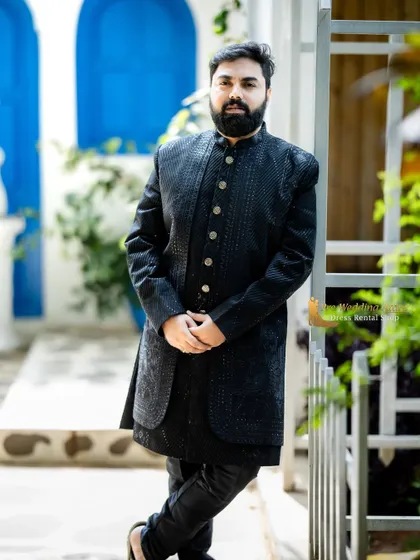 The black sherwani styled for a relaxed yet polished look. It's a versatile piece that works in various settings, from grand palaces to modern photo studios.