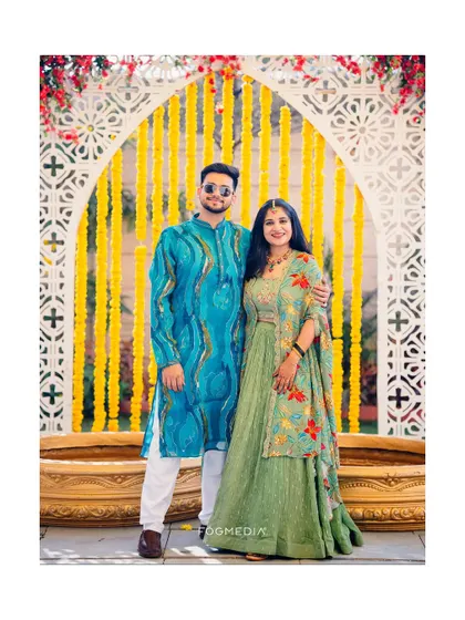The happy couple posing in their colorful Haldi outfits, a perfect portrait to remember the day.