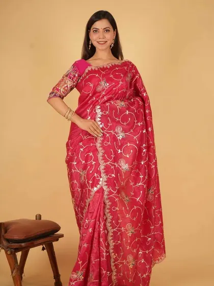 This vibrant pink organza saree is pre-stitched for your convenience. It features intricate silver embroidery, offering a festive look that you can achieve in just a minute. It’s a perfect blend of traditional design and modern practicality.