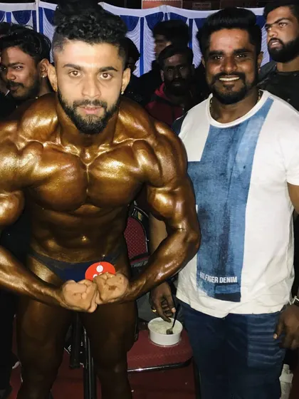 With my uncle and mentor, Kitty Murthy, at a competition. His presence and guidance have been the cornerstone of my success on the bodybuilding stage.