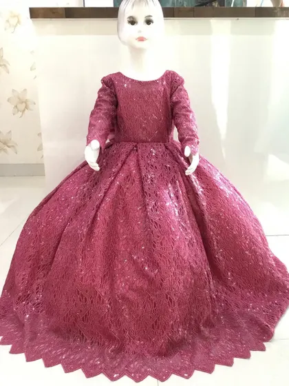 A full-length view of a sequined deep pink ball gown for a child.