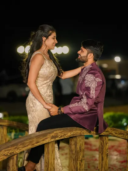 A candid moment between the couple, showing another angle of the custom purple bandhgala jacket. The fit is tailored to be comfortable whether standing or sitting, perfect for long events.