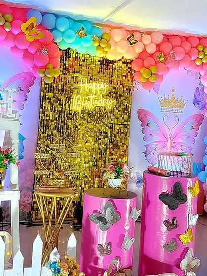 A closer look at the main stage for this colorful butterfly party, showing the themed cake pedestals and large number '1' prop.