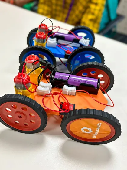 A lineup of colorful DIY cars built by students at a workshop at Yahoo India. Each car is a testament to the student's effort in wiring the motors and assembling the chassis.