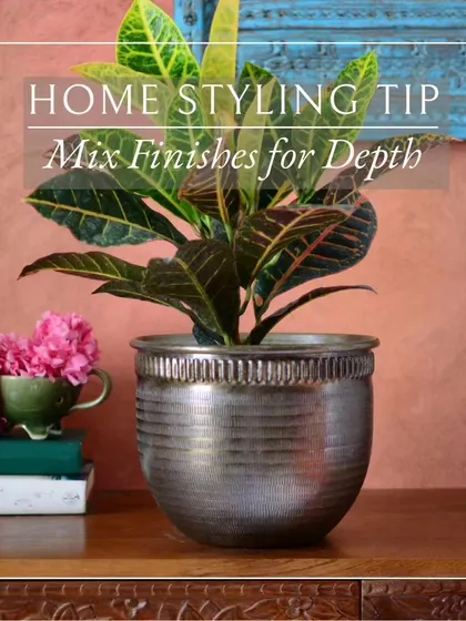 Styling your home is all about creating visual interest. This image shows how a textured bronze planter can be the perfect centerpiece for a console table, adding a touch of rustic elegance.
