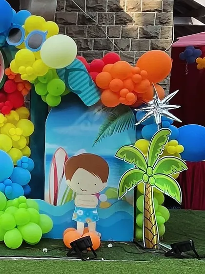 This pool party backdrop includes a cute cartoon boy, a palm tree, and a wave cutout.