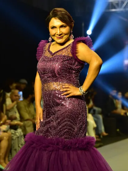 A closer look at the intricate beadwork on the plum purple mermaid gown. The sheer panels and ruffled shoulders add a touch of modern sophistication.