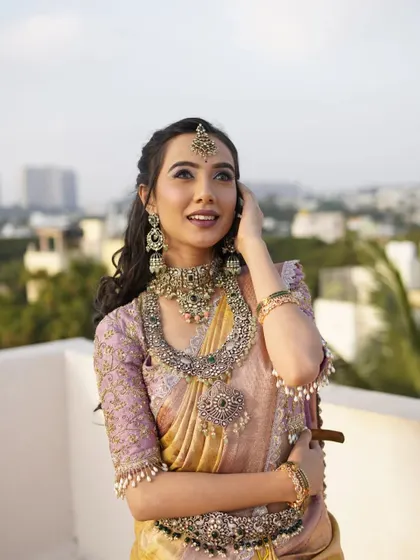 A beautiful, dreamy shot of the model looking up, highlighting the maang tikka and the soft waves in her hair.
