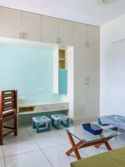A multi-functional room setup that includes a long study desk integrated with a wall of wardrobes. This is a great space-saving solution for a guest room or a child's bedroom.