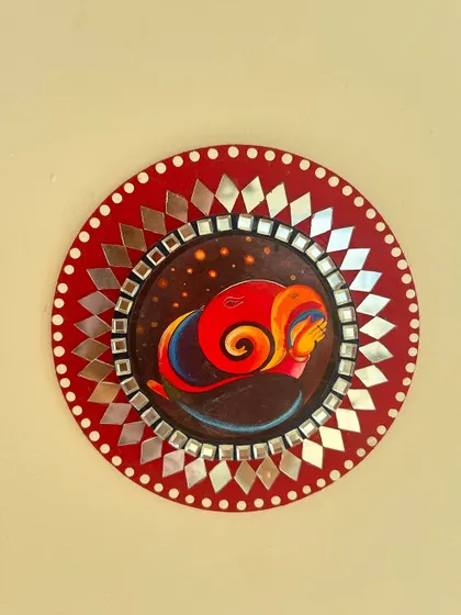 A similar Ganesha-themed mirror art piece, this time with a vibrant red background.