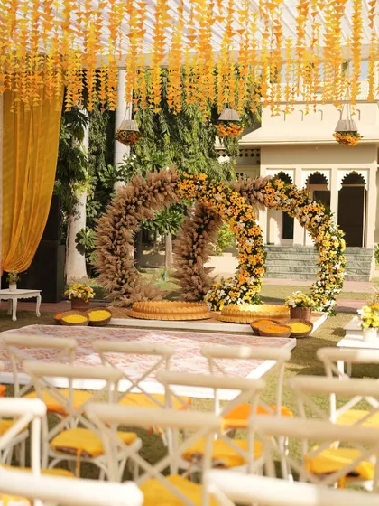 A wider view of the sunflower-themed Haldi setup, showing the seating arrangement and the beautiful circular backdrop. The entire space is designed to feel bright and joyful.