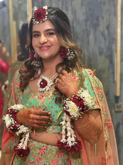 A close-up of the bride, showing off her beautiful smile and the intricate floral jewelry. The makeup is subtle yet effective, giving her a radiant glow.