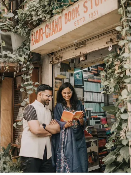A candid moment captured outside a charming Khan Market bookstore. This style is perfect for urban couples, telling a story that feels authentic, personal, and rooted in the city you love.