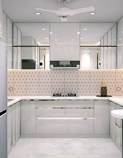 Another angle of the all-white kitchen, showing the integrated refrigerator and ample storage, highlighting the seamless and minimalist aesthetic.