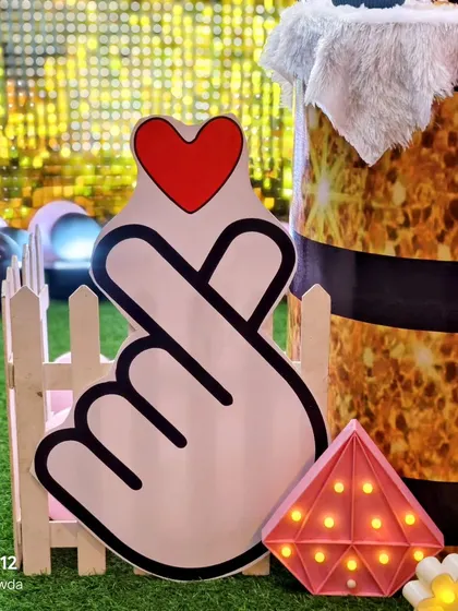 A large cutout of the K-Pop finger heart symbol, perfect for photo's at a Blackpink or BTS themed party.
