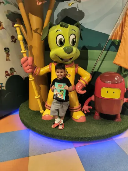 A happy superstar holds up his Tingaland activity book while posing with our mascots. We offer various add-ons and souvenirs to make the day extra special.
