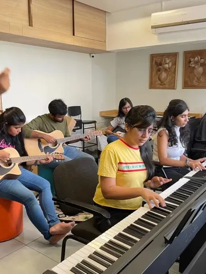 A group of Google employees learning keyboard and guitar in our workshop.
