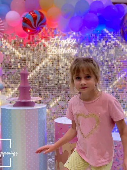 A happy guest enjoying the vibrant atmosphere of the Candyland party. The colorful lights and decorations create a fun and festive mood for everyone.