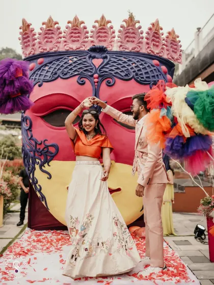 The couple twirling on stage at their vibrant carnival party.