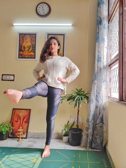 Practicing a standing leg lift. This pose not only challenges your balance but also strengthens your leg muscles and core, teaching you to find stability from within.